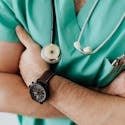 Doctor in scrubs with folded arms and stethoscope, symbolizing confidence in healthcare.