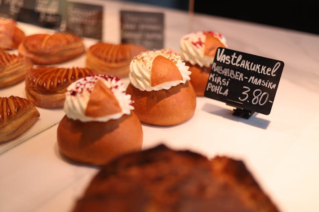 Appetizing pastries with cream and toppings, displayed in a bakery setting.