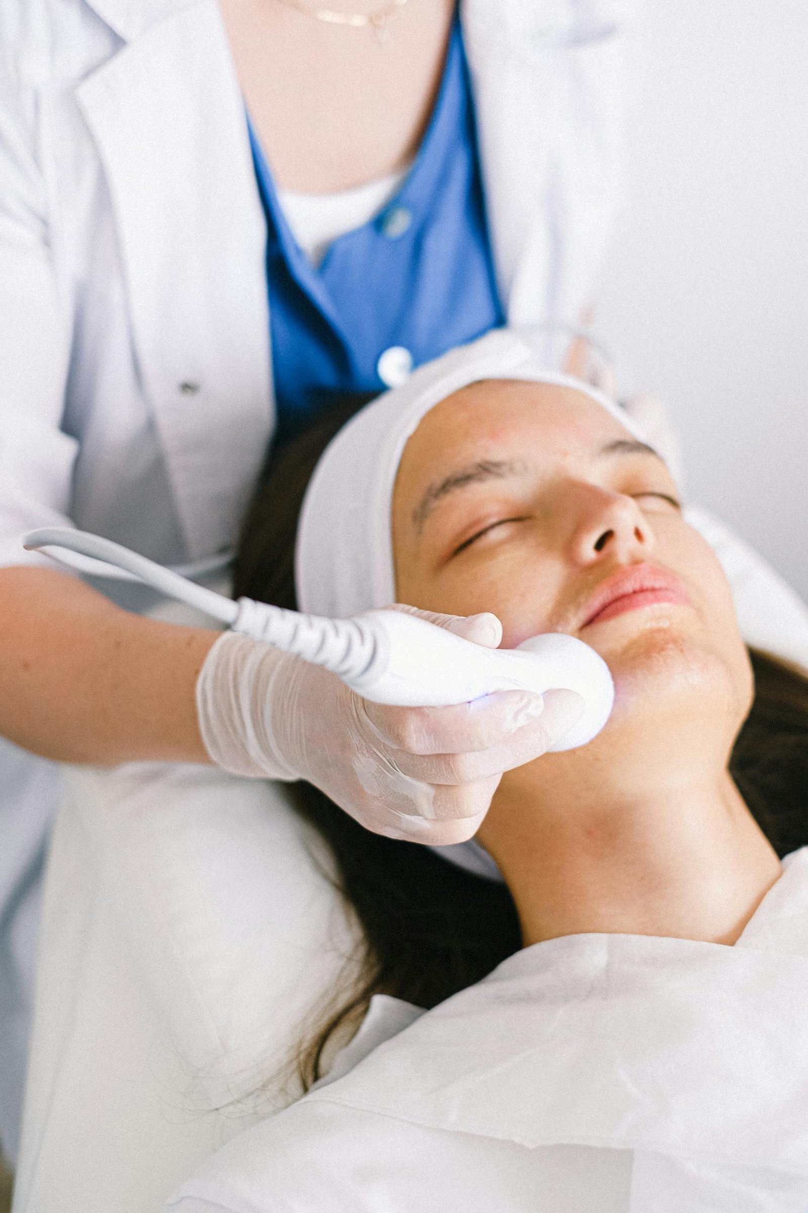 Woman receiving ultrasonic facial treatment at a modern spa clinic, enhancing skincare and relaxation.