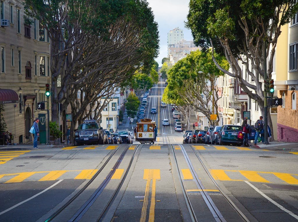 A vibrant city street in San Francisco featuring a classic cable car and iconic architecture.