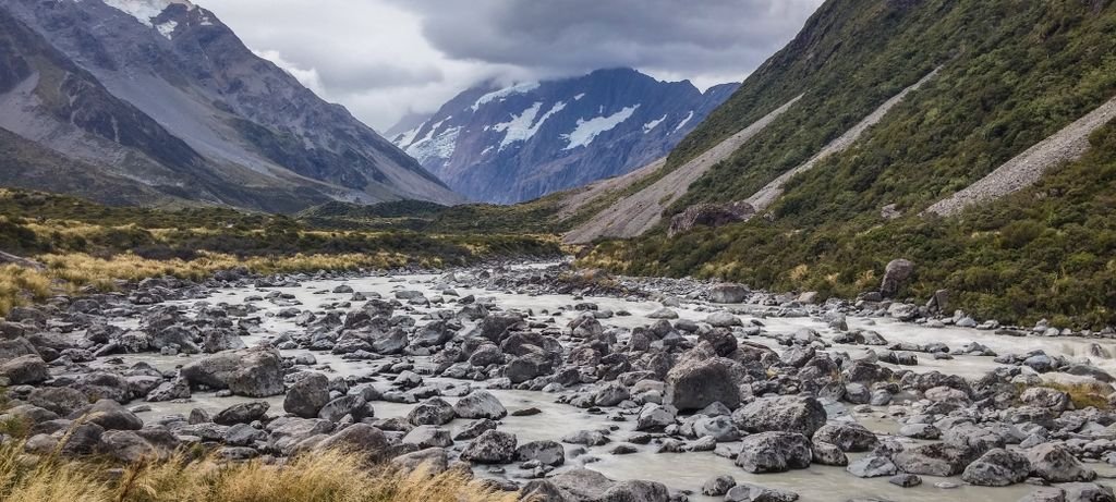 Breathtaking mountain valley with rocky river and lush green surroundings.