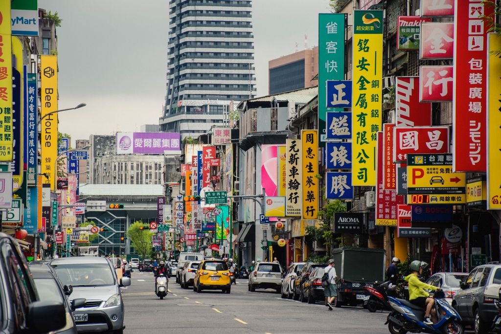 Bustling Taipei street with colorful signs and busy traffic, showcasing urban life in Taiwan.