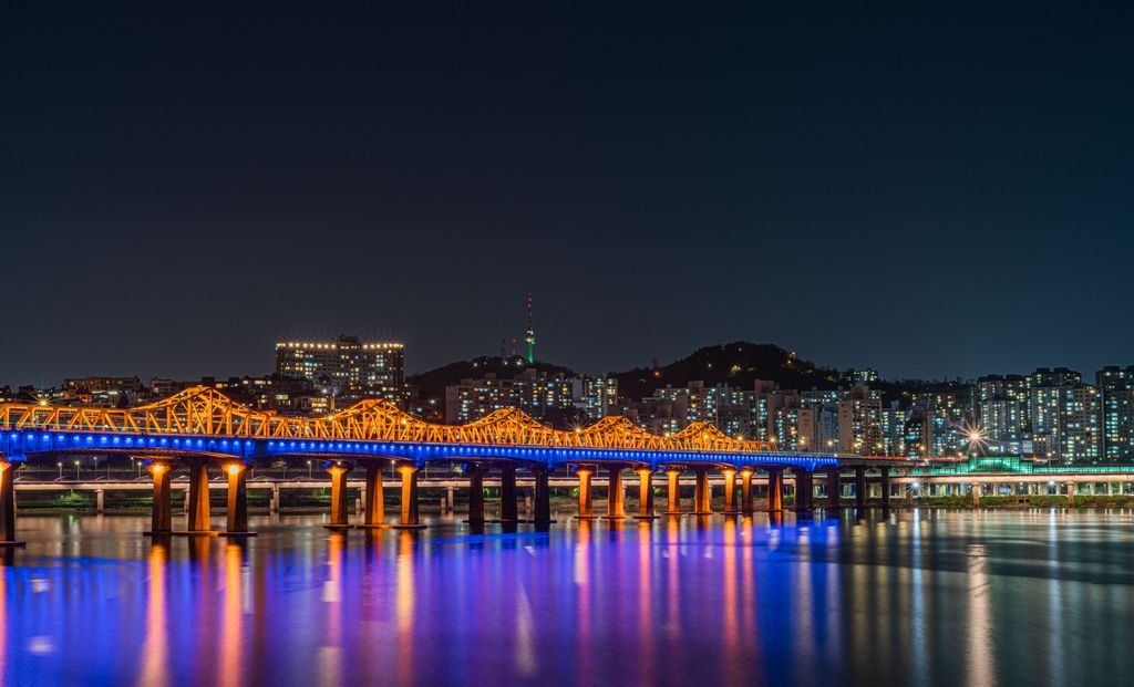 Stunning night view of Seoul skyline with an illuminated bridge over the Han River. Vibrant cityscape.