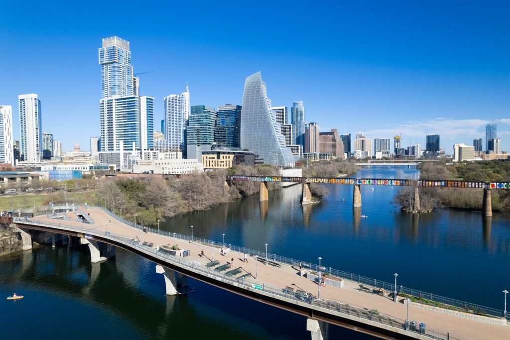 Aerial view of the modern Austin skyline featuring bridges over the river and towering skyscrapers.