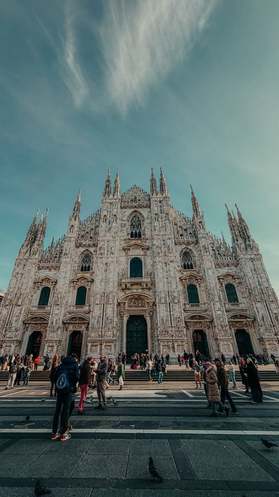 Explore the iconic Duomo di Milano, a masterpiece of Italian Gothic architecture, bustling with visitors.
