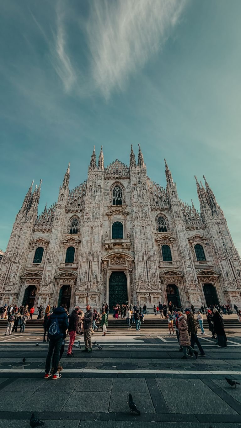 Explore the iconic Duomo di Milano, a masterpiece of Italian Gothic architecture, bustling with visitors.