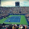 Thrilling tennis match at the US Open tennis with a full stadium of enthusiastic fans.