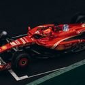 Dynamic shot of a red Formula One car racing on a track, showcasing speed and precision.